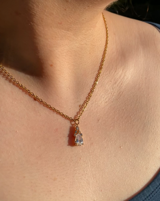 Necklace with a tear pendant worn by a person