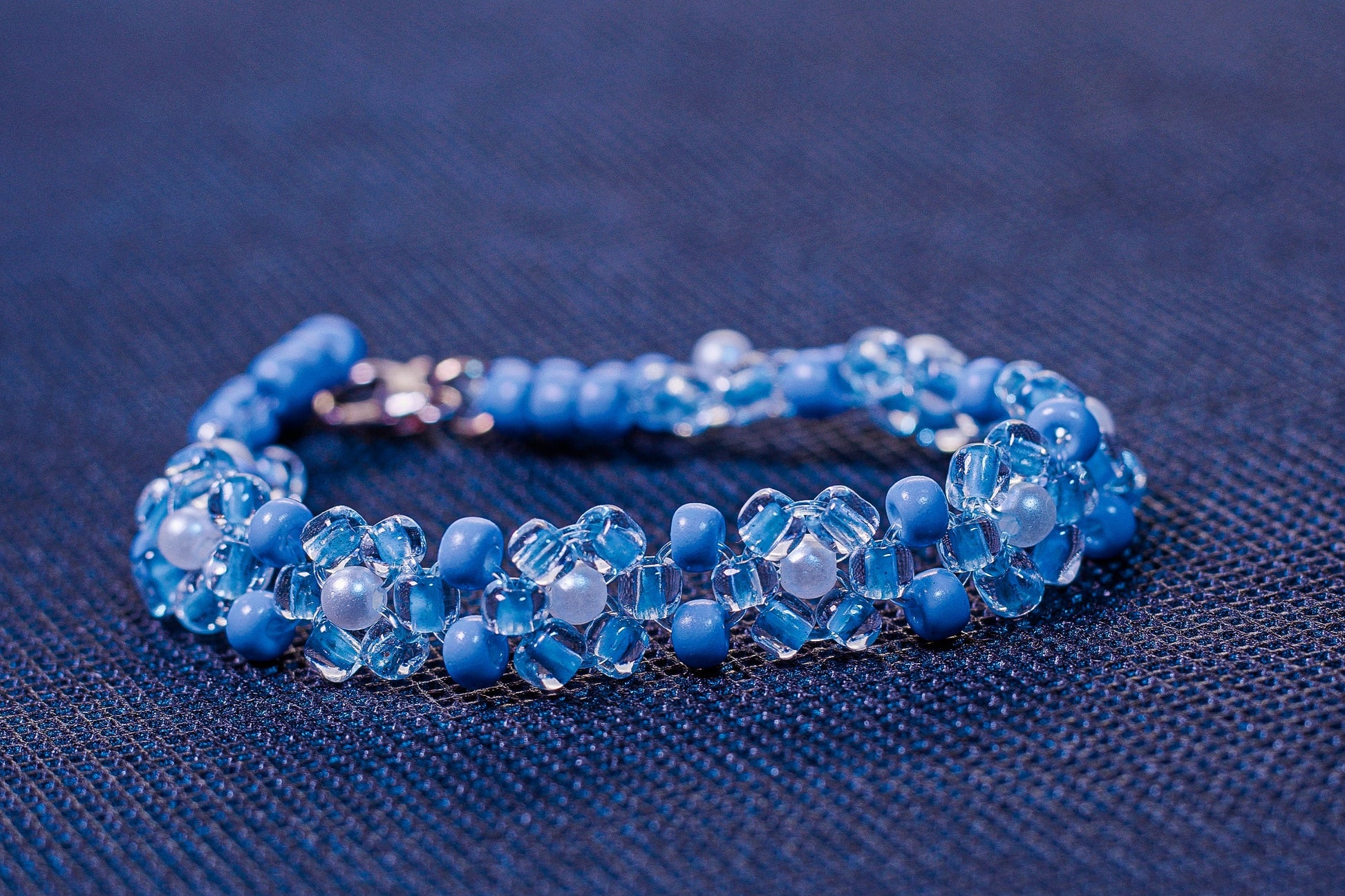 Blue beaded bracelet on a blue fabric background